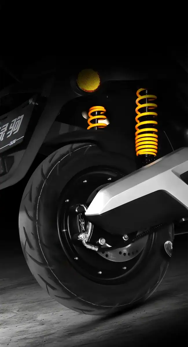 Close-up of Dawnray electric scooter front wheel with yellow suspension springs and tire, showcasing modern design and engineering.